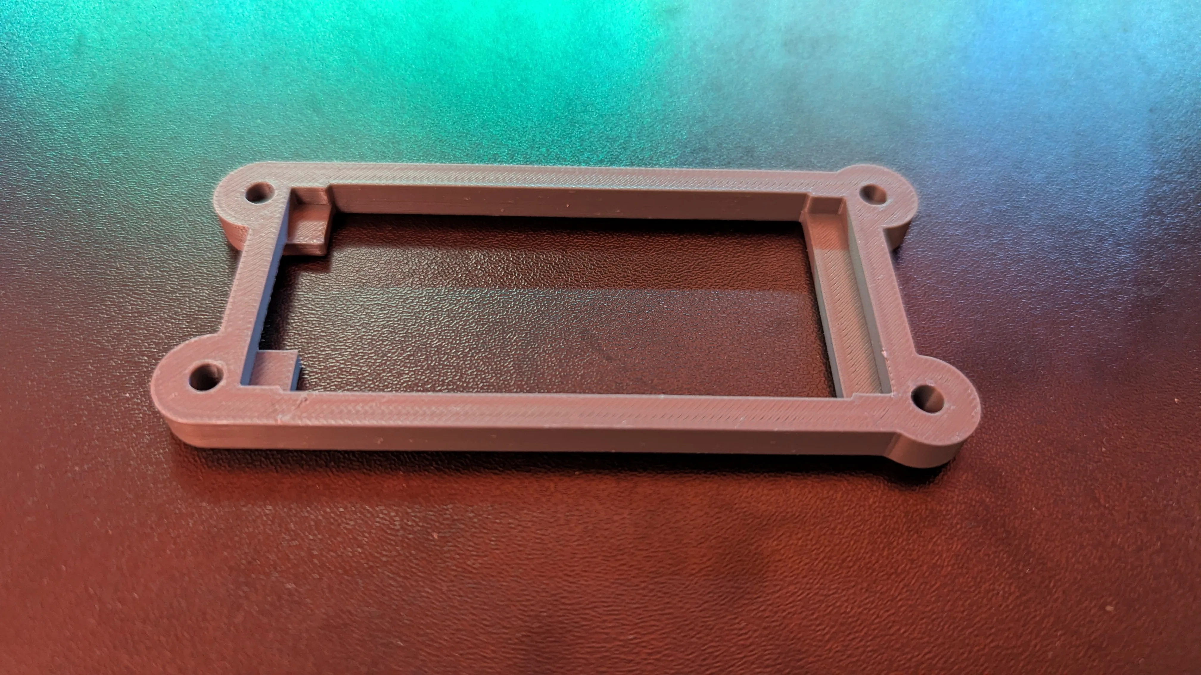 Custom 3D-printed electronics board mount with screw holes and accessible connection area